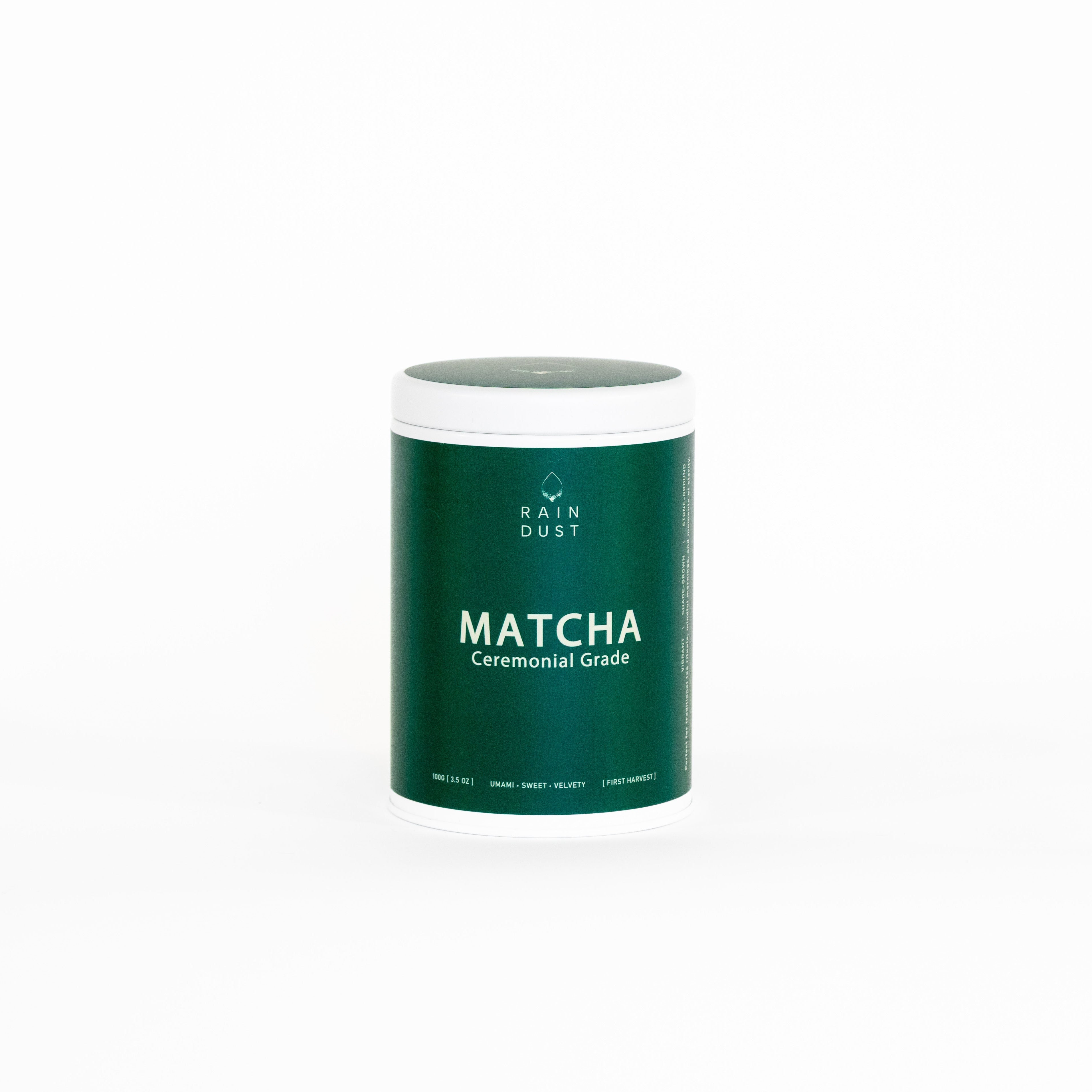 Green container of matcha powder with white lid on a white background