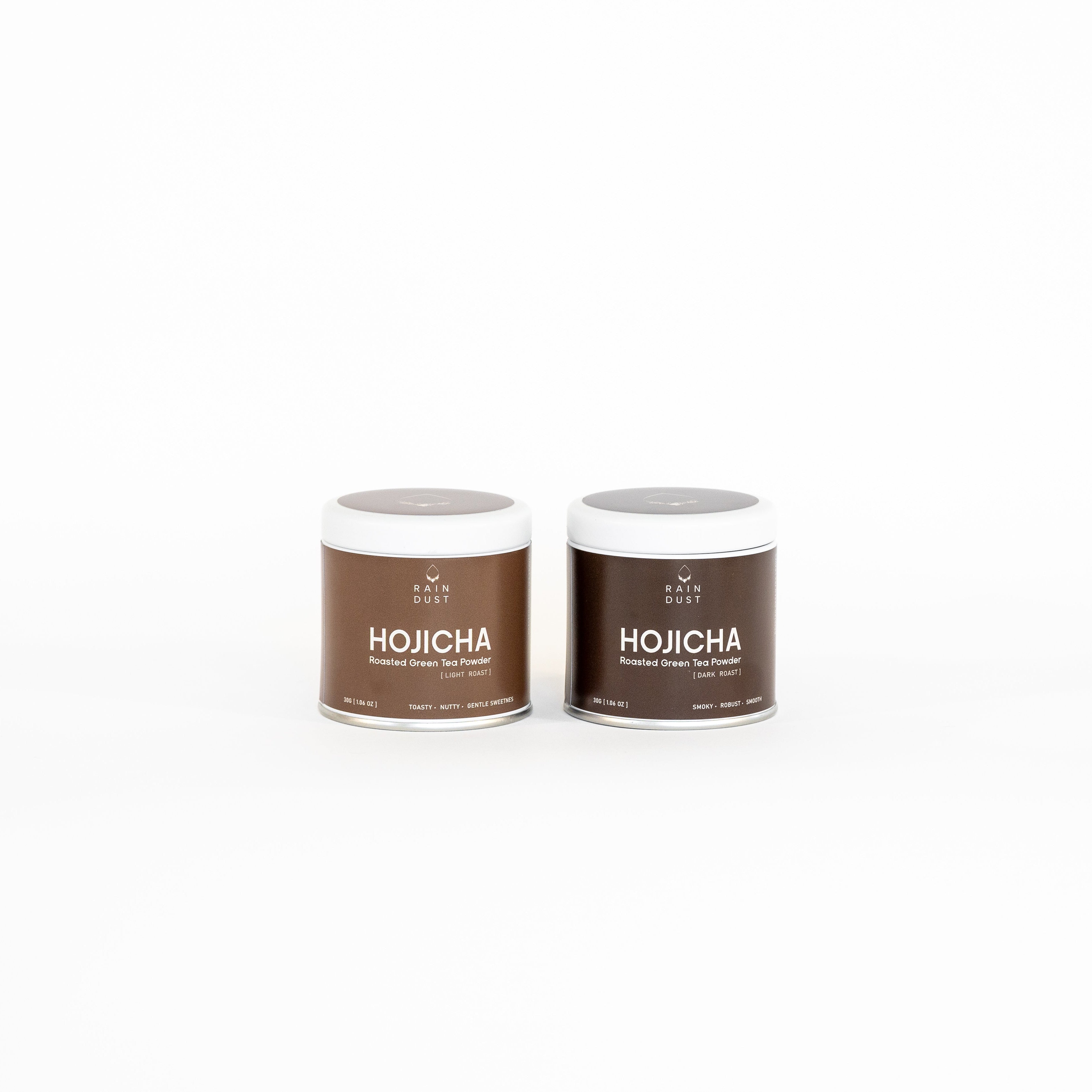 Two containers of Rain Dust Dark & Light Roast Hojicha on a white background