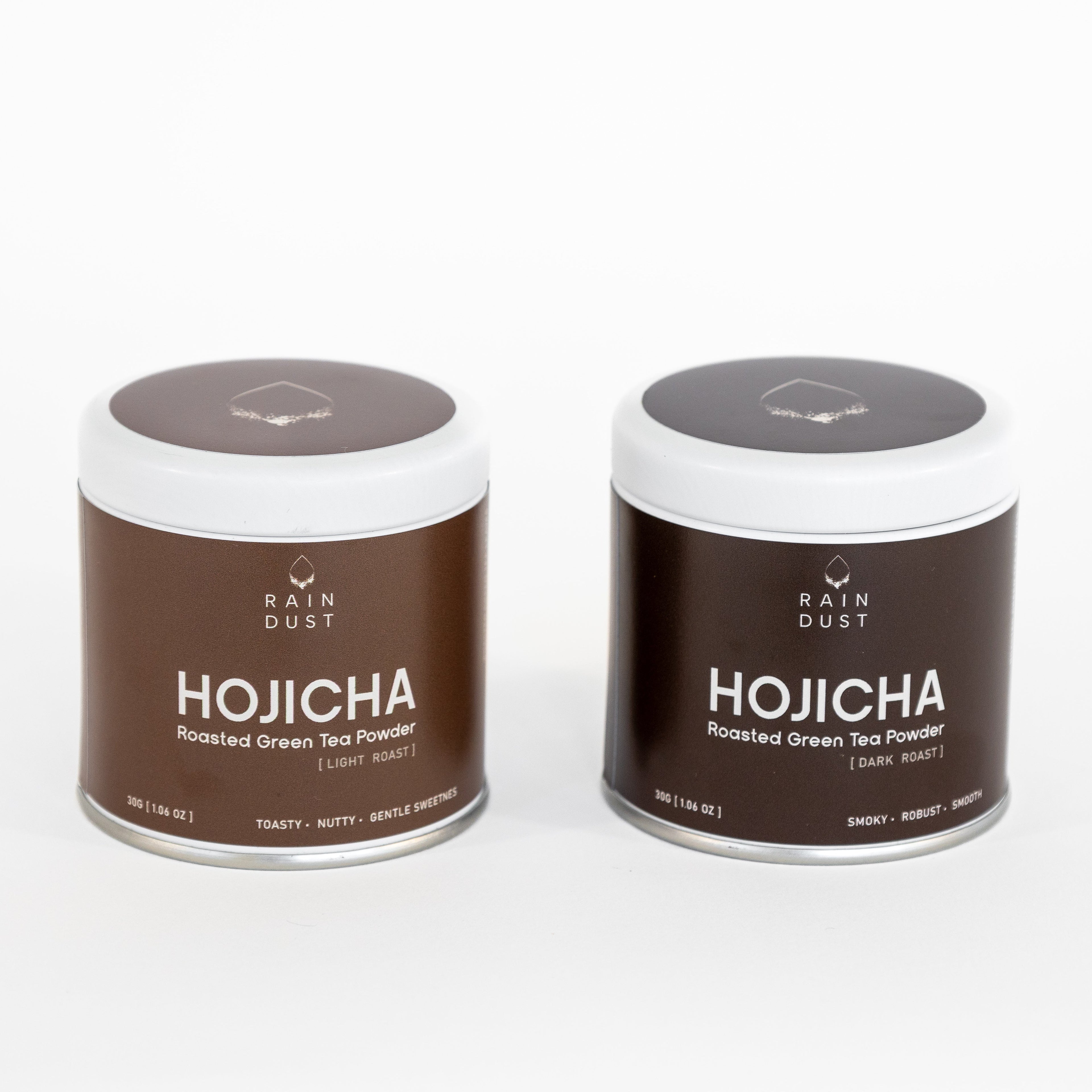 Two containers of Rain Dust Premium Hojicha roasted green tea powder on a white background