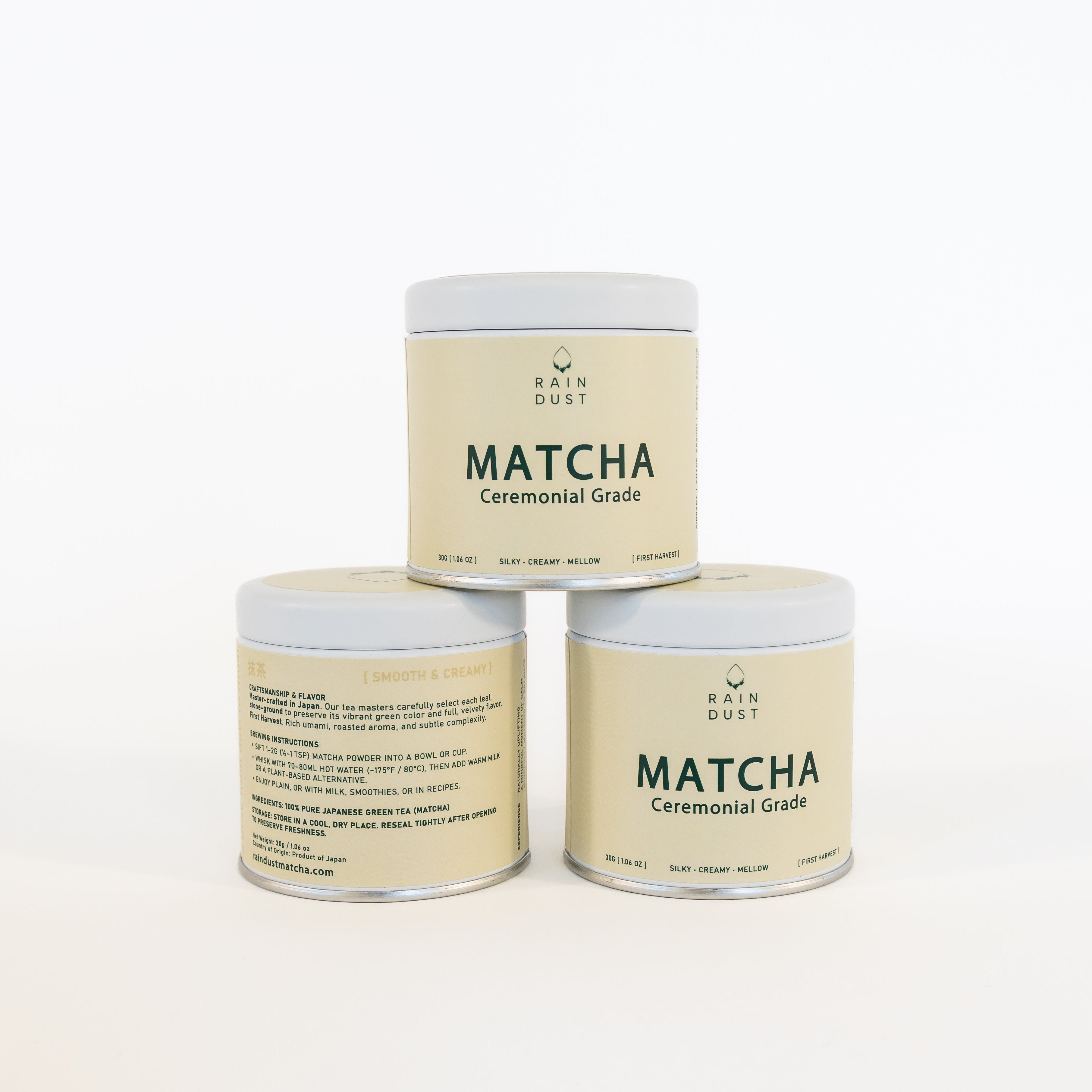 Three containers of  raindust ceremonial matcha green tea powder on a white background
