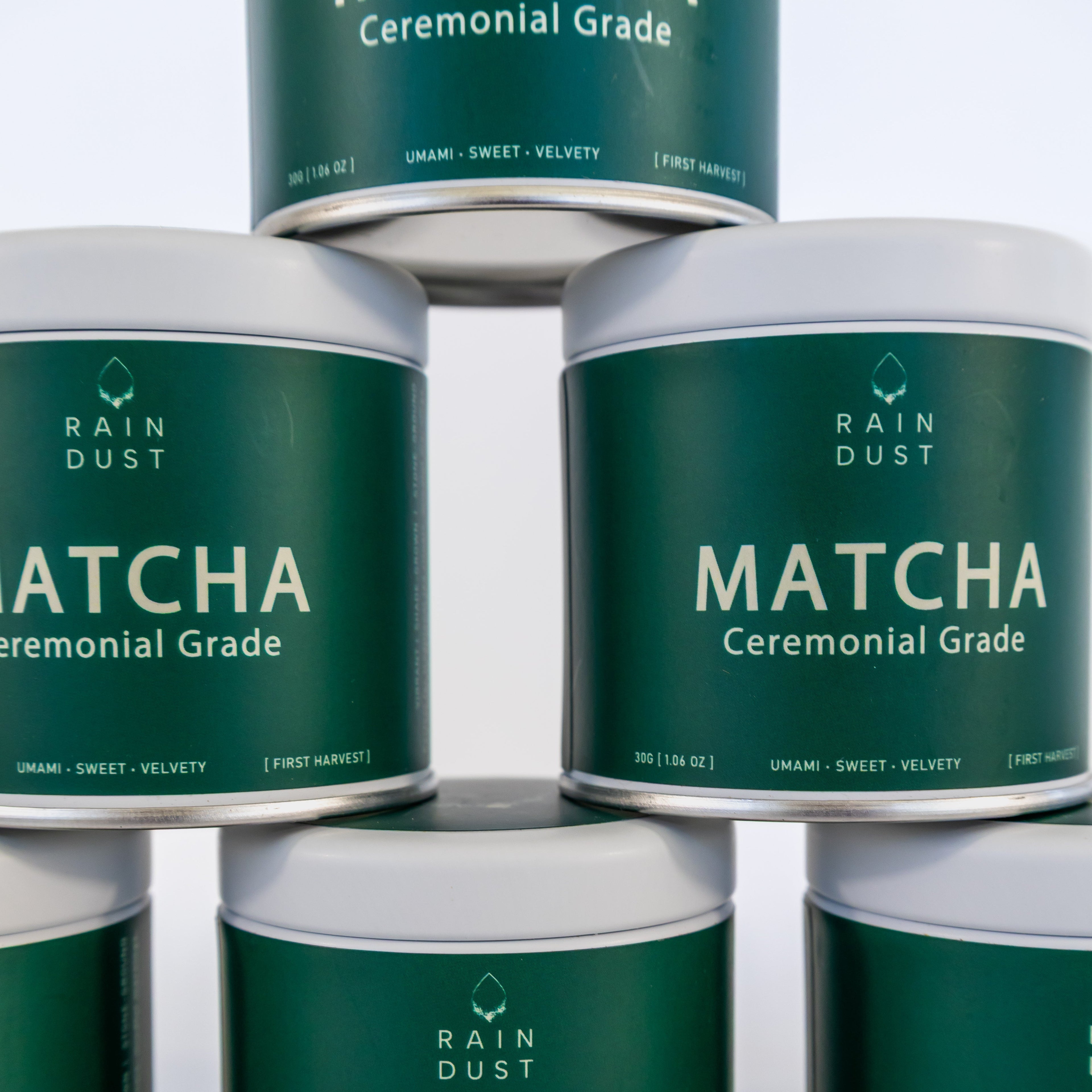 Multiple tins of Rain Dust Matcha Ceremonial Grade on a light background