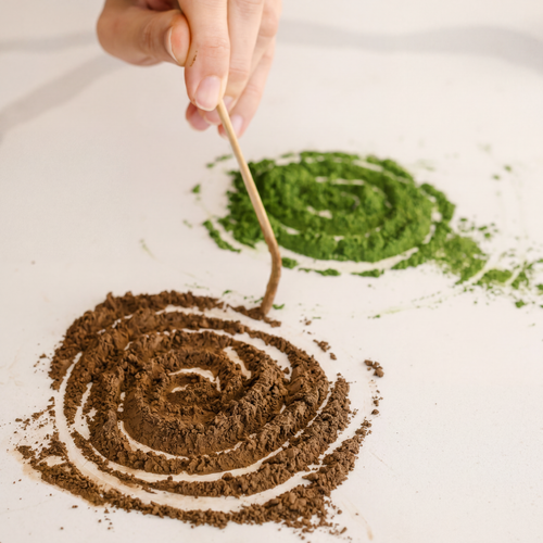 Creating a spiral pattern with organic dark roast hojicha & matcha powder on a white surface. The best Hojicha and matcha powder in Toronto, Canada