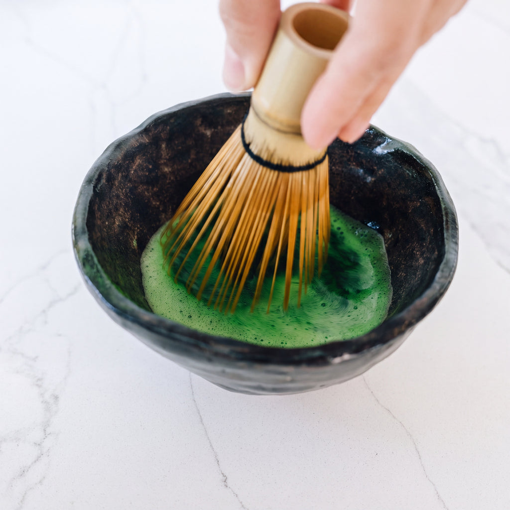 Rain Dust ceremonial grade Japanese matcha being whisked into a smooth frothy tea using a traditional bamboo whisk.